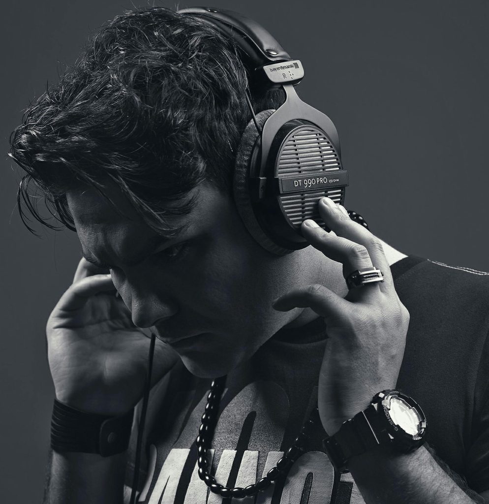 Iranian music producer wearing headphones, showcasing a modern and edgy style.