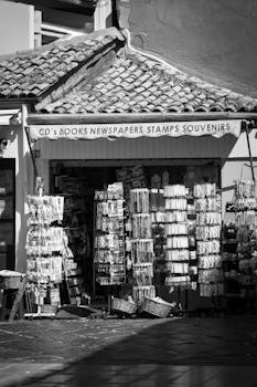 Charming black and white image of a Greek souvenir shop in Corfu, showcasing Mediterranean architecture.