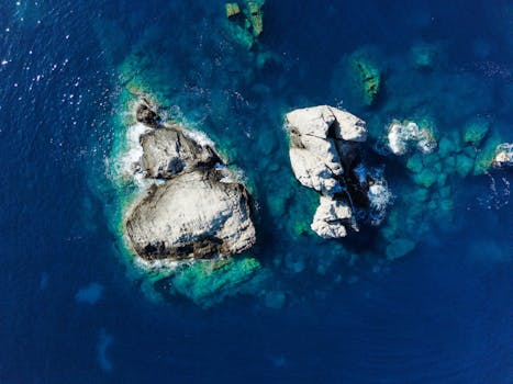 Stunning aerial shot of rocky formations in azure waters off the Greek coast, showcasing the Ionian Sea's vibrant colors.